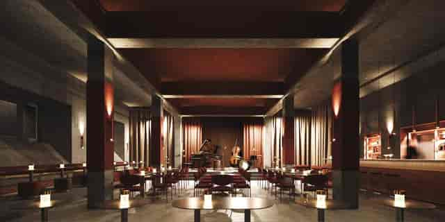 Industrial-chic Atrium venue with pillar architecture for corporate events and jazz performances.