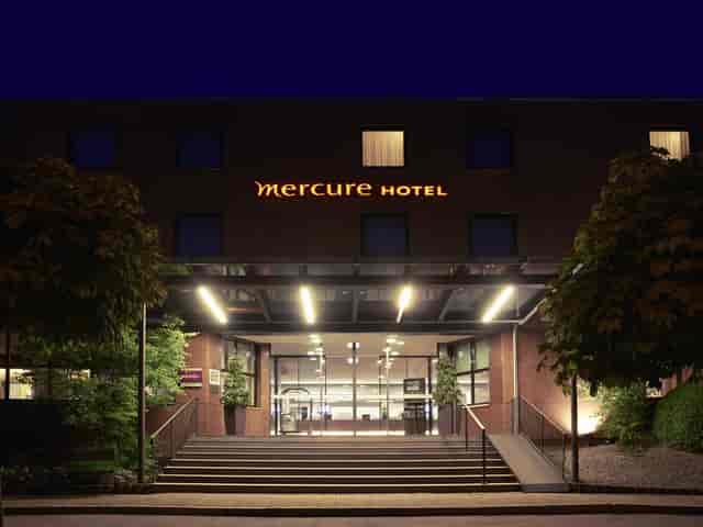 Mercure Hotel Muenchen Sued Messe exterior at twilight, corporate event venue and business hotel.
