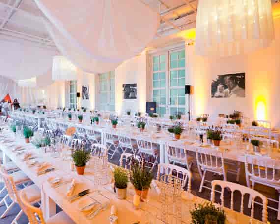 Terrassensaal banquet: White-on-white long-table setup with fabric draping for corporate events.