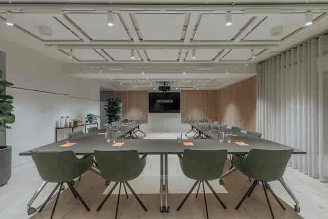 Modern meeting room with a large table and screen at Uncommon Holborn for conferences.