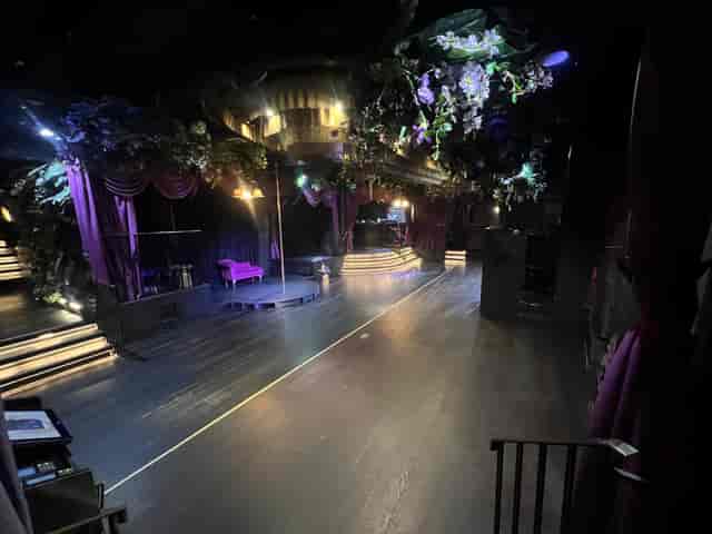 Mood-lit Soho venue with stage and floral decor for gala or experiential activation event.