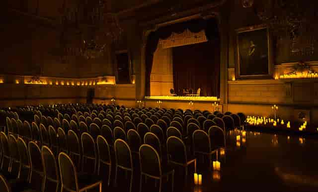 Concert Noble hall with candlelit theater setup for exclusive keynote or corporate fireside chat.