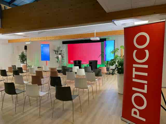 Fireside chat stage with dual-screen AV for professional corporate event and conference setup.