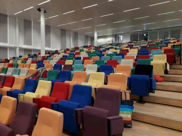 Multicolor tiered auditorium at MEET S.10 for large-scale corporate events and presentations.