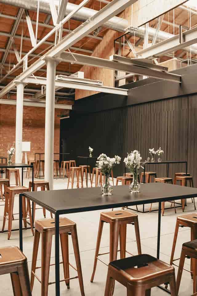 Industrial-chic event stage with high-top seating for networking receptions and corporate venues.