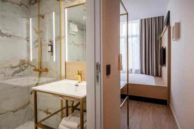 Modern Jill Hotel Brussels room with open-plan bathroom for business travel and event lodging.
