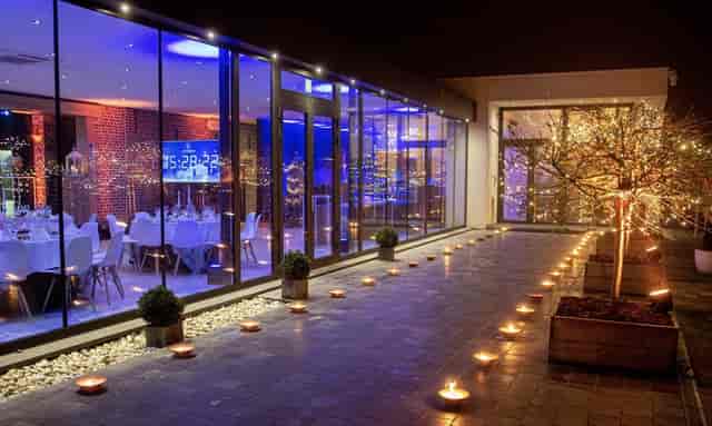 Modern glass event hall in Kattebroek with ambient lighting for corporate dinners and social galas.