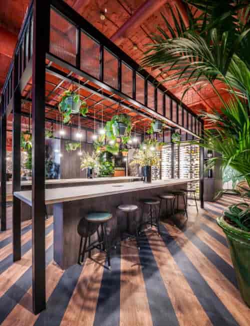 Upscale garden kitchen event space with biophilic design for networking and cocktail receptions.