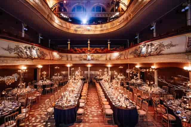 Candlelit gala dinner at The Salle des Clés, featuring tiered historic architecture and long tables.