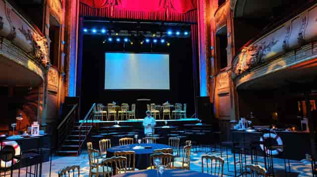 Corporate banquet setup in Théâtre du Vaudeville with tiered stage for event hosting.