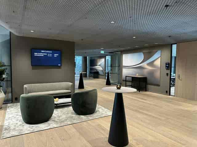 Modern corporate networking lounge at SIXA Conference with soft seating and digital signage.