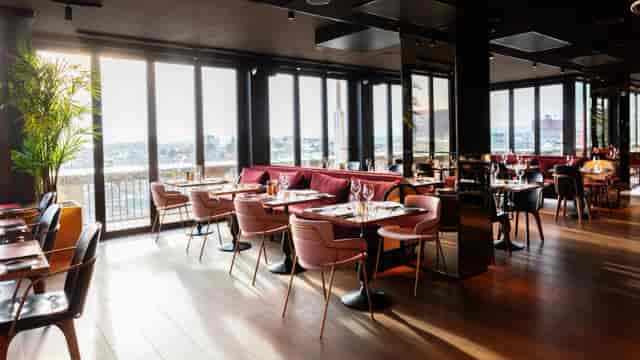 Upscale Clarion Hotel Oslo restaurant with floor-to-ceiling windows for corporate networking events.