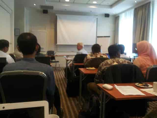 Ludvig at Scandic Holberg: empty projection screen in a classroom-style meeting room setup.