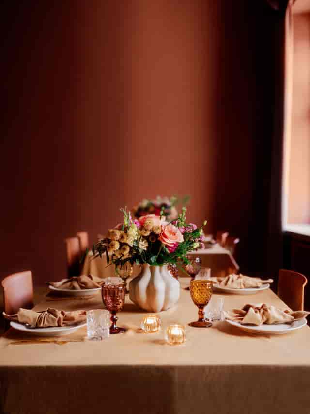 Executive dinner setup at Møterom Kjøpmannen, Handelens Hus with elegant floral banquet decor.