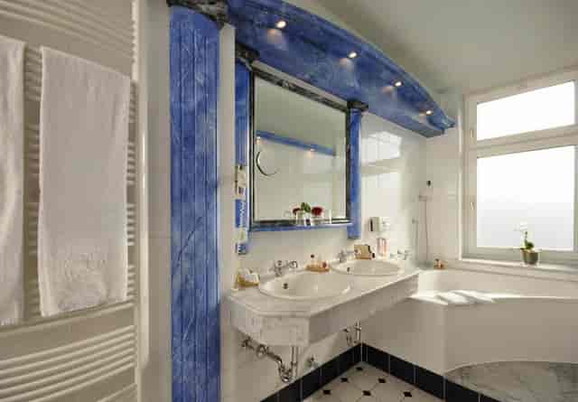 Retro blue-tiled bathroom at Hotel Torbräu, ideal for business travel and corporate event lodging.