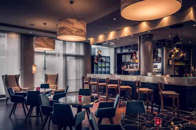 Modern hotel lounge in Pageou with bar for networking events and corporate breakout sessions.