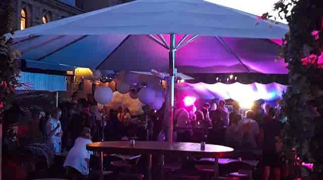 Outdoor networking event at Lawo Terrasse bar with branded umbrella and ambient decor.