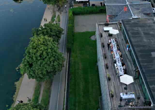 Riverside banquet hall with linear tables, ideal for outdoor wedding receptions and gala events.