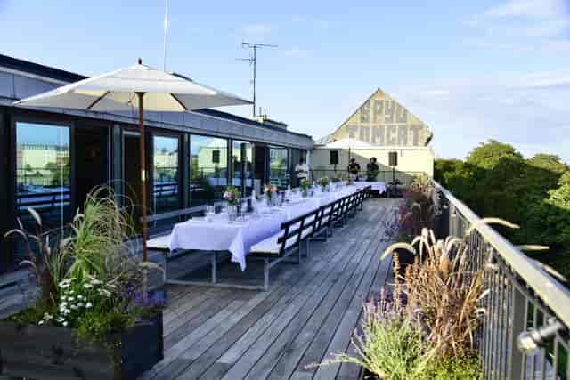 Rooftop restaurant with communal seating for corporate dinners and networking events.