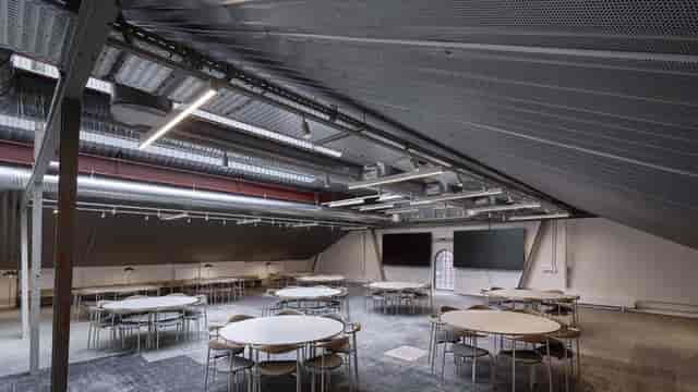 Industrial-chic meeting room with vaulted ceiling for creative workshops and corporate events.