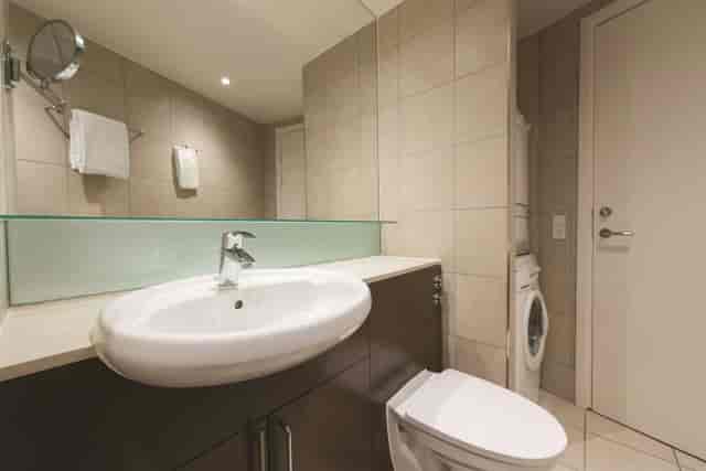 Modern hotel bathroom with in-unit washer-dryer, ideal for business travel and event accommodation.