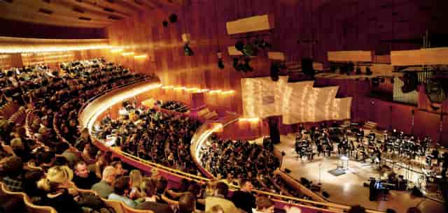 Tiered auditorium at The Concert Hall with stage rigging for plenary sessions and keynotes.