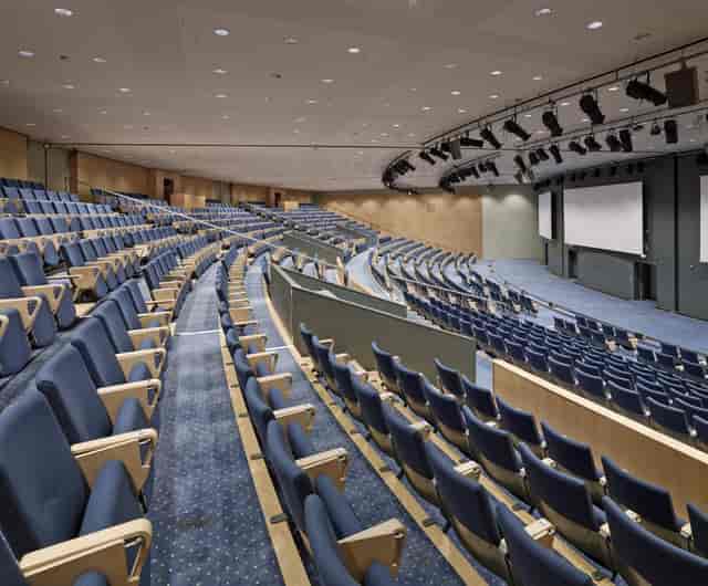 Auditorium conference room with tiered seating for corporate events and plenary sessions.