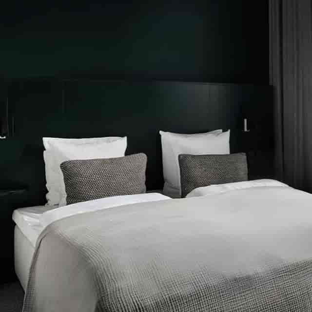 Minimalist Hotel Hans executive suite: moody aesthetic for upscale corporate room blocks.