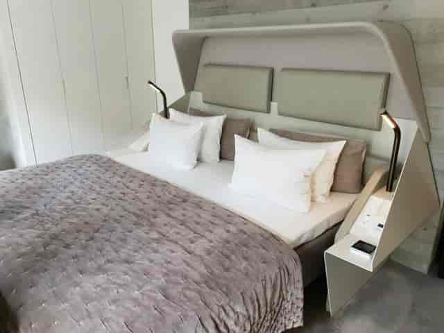 Modern hotel guest room with sleek multifunctional headboard for business travel and accommodation.