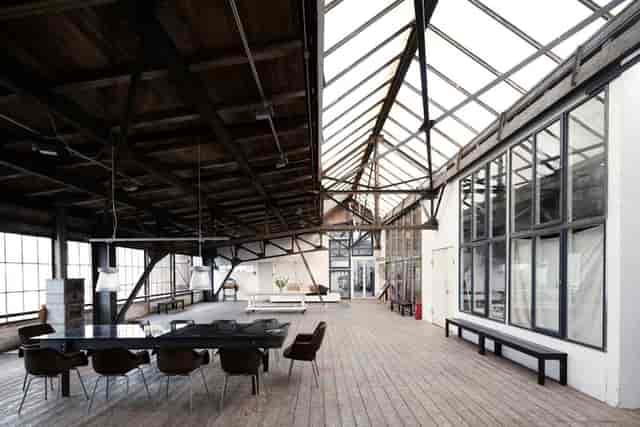 Industrial-chic loft with sawtooth glass ceiling for creative workshops and product launches.