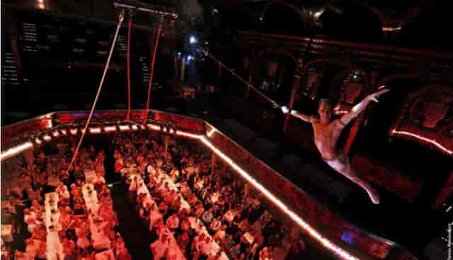 Aerial performers at a Paradis Latin gala dinner in a historic theater for corporate events.