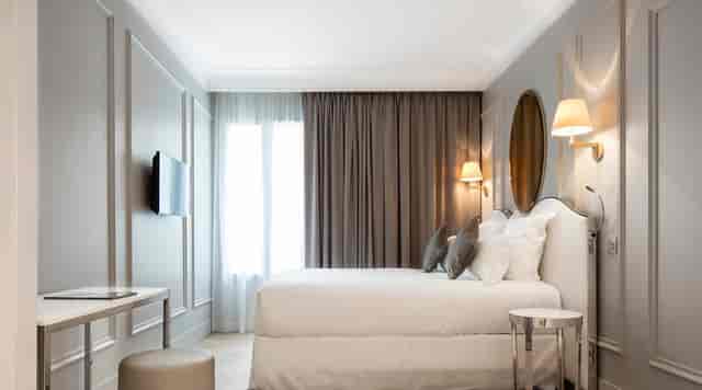 Modern guest room at Maison Pigalle hotel featuring a dedicated desk for business travel events.