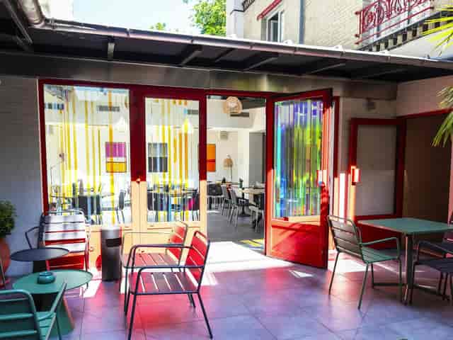 Porte de Versailles hotel break-out space, sunlit indoor-outdoor venue for networking and events.
