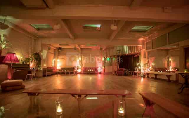 Industrial-chic loft dance hall with ambient lighting for networking events and cocktail receptions.