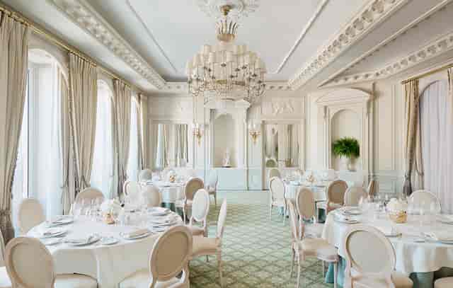 Elegant Ritz Paris banquet hall with crystal chandelier for corporate galas and luxury dinners.
