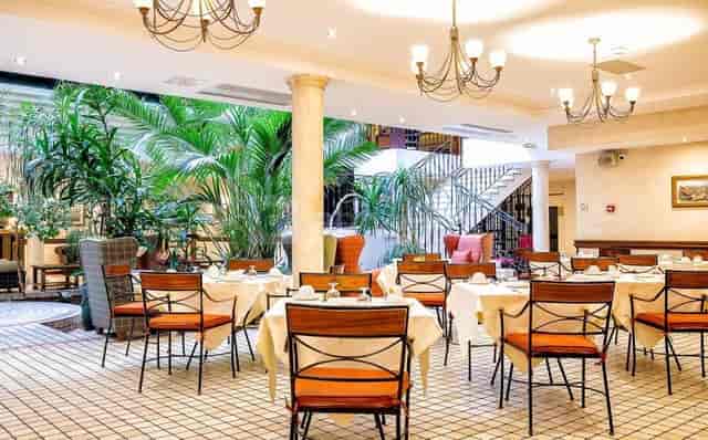 Sunlit Le Salon Figaro atrium, Mediterranean aesthetic, networking breakfast, private event venue.