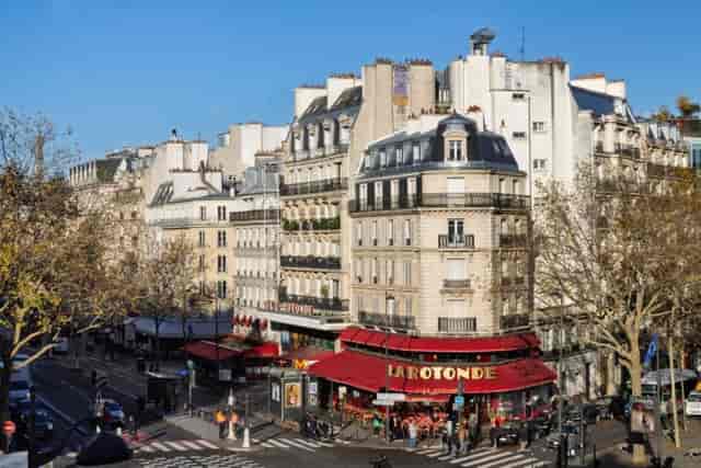 Hôtel Raspail Montparnasse suite overlooking a classic Parisian street corner for networking events.