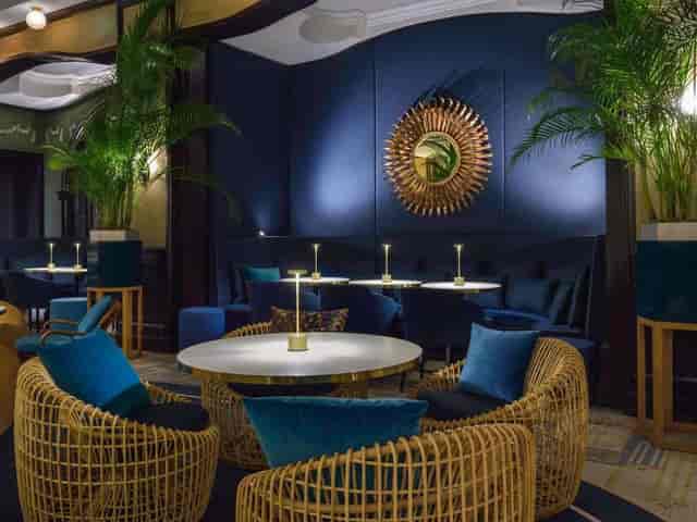 Salon des Princes lounge: navy and rattan VIP networking event or upscale cocktail venue in Paris.