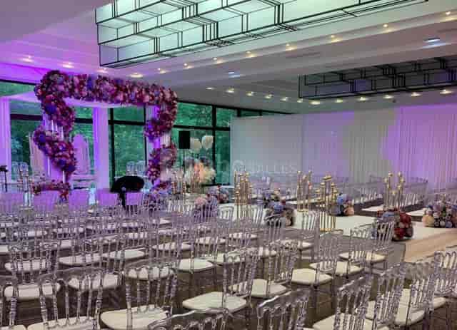 Modern wedding ballroom at Le Salon Toffoli with floral arch and ghost chairs for event hire.