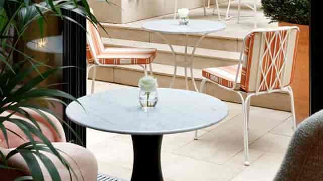 Patio terrace at Le Belgrand Hotel Paris with marble bistro tables for cocktail receptions.