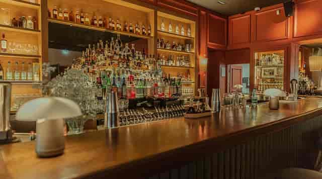 L'Officine cocktail bar with warm lighting for corporate networking and VIP reception events.
