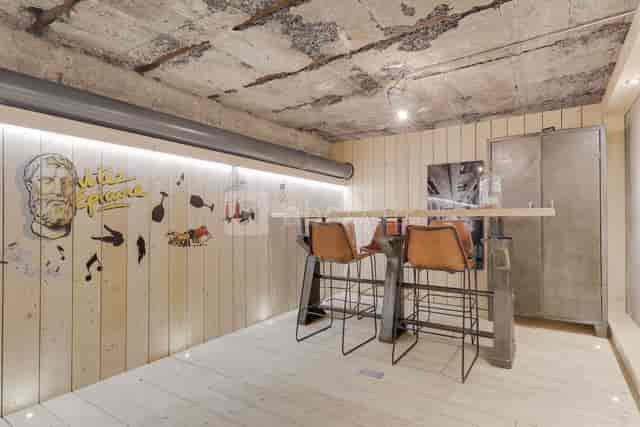 Industrial-chic banquet hall with concrete walls for networking and creative brainstorming events.