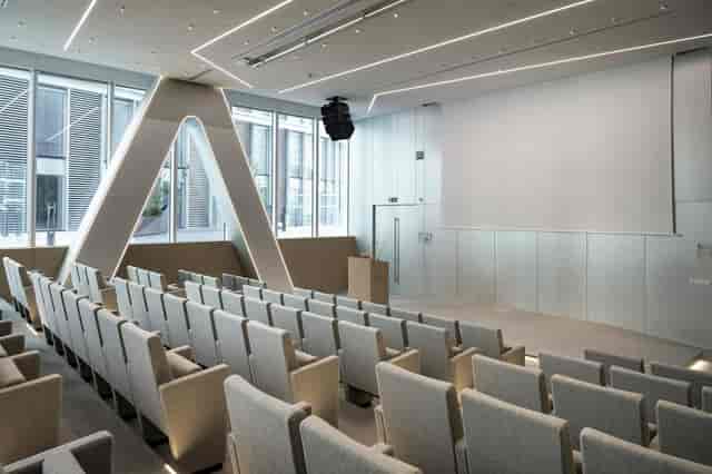 Modern auditorium with tiered seating at Wellio Lyon for corporate presentations and seminars.