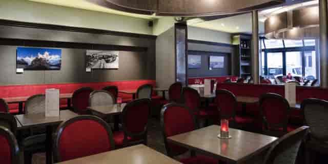Stylish Le Marly bar with warm red tones, perfect for intimate gatherings and meetings.