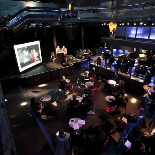 Industrial-chic Transbordeur theater with cabaret seating for corporate presentation events.