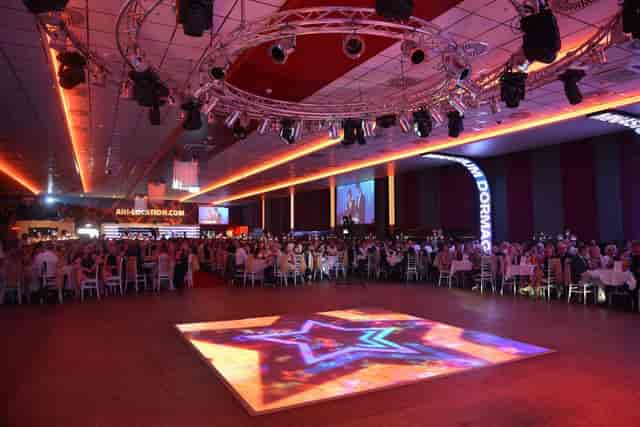 Gala dinner setup at Saal 2 Elegance Eventlocation with LED dance floor and circular lighting rig.