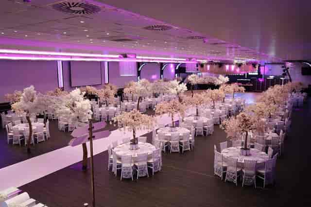 Elegant ballroom with cherry blossom centerpieces for a wedding or gala event.