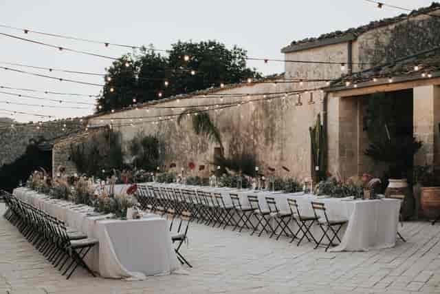 Al fresco banquet at Scheune in Glasvoll Düsseldorf with elegant string lighting for events.