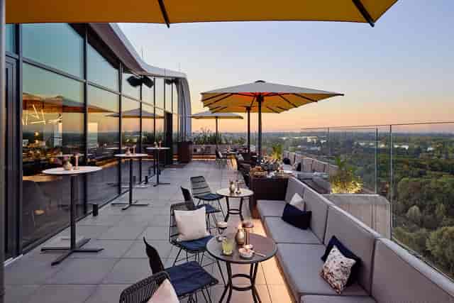 Corporate cocktail reception on The Roof Dusseldorf terrace at sunset for networking events.