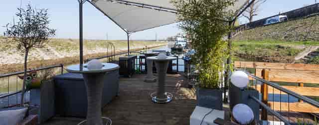 Covered outdoor function deck at Fischers Kahn with cocktail tables for networking and receptions.